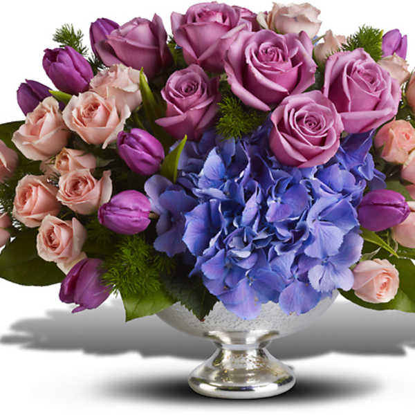 Lavender and pink roses with blue hydrangea in a silver vase