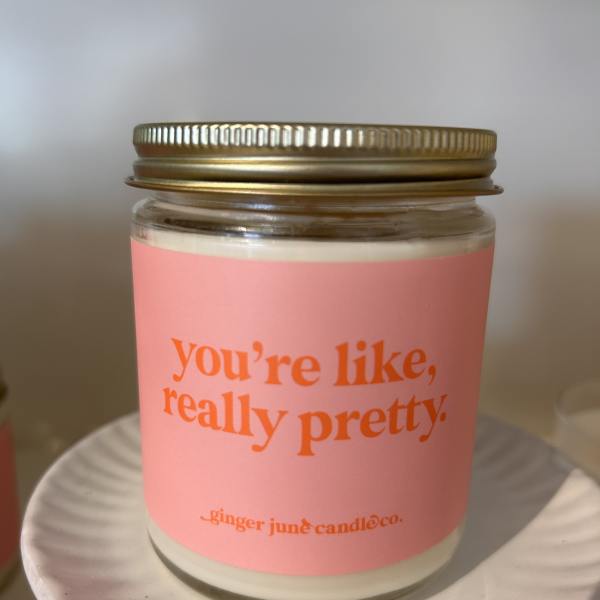 Pink candle in a glass jar with a gold lid