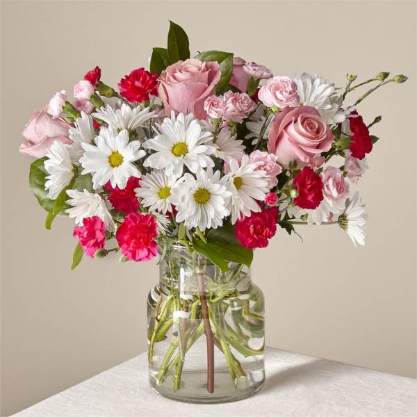 Pink roses and white daisies in a clear glass vase
