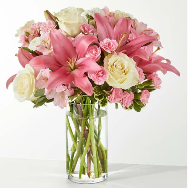 Pink lilies and cream roses in a clear glass vase