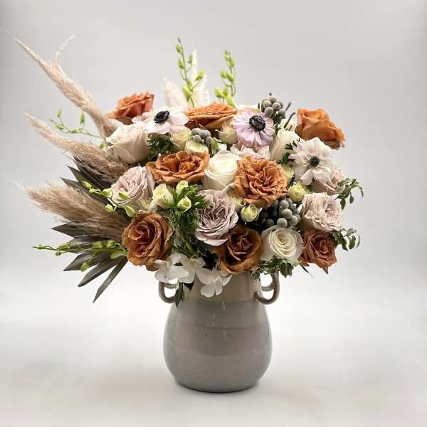 Bouquet of peach and white roses in a gray vase
