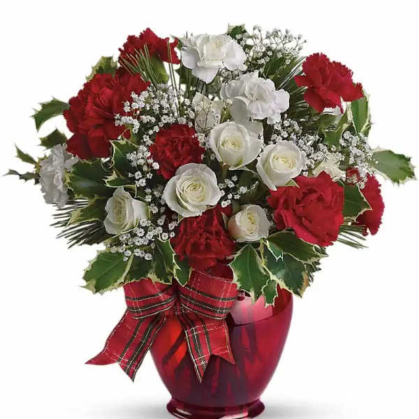 Red and white carnations and roses in a red glass vase with a plaid bow