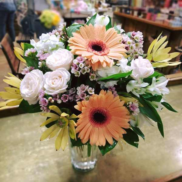 Bouquet of peach gerbera daisies and white roses in a clear glass vase