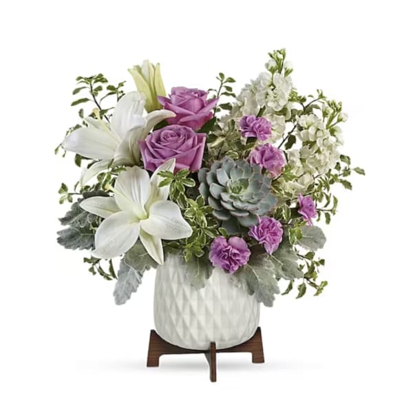 Bouquet of white lilies, purple roses, and succulents in a white vase