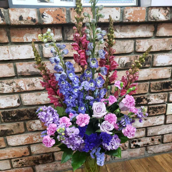Tall bouquet of purple and pink flowers in a glass vase