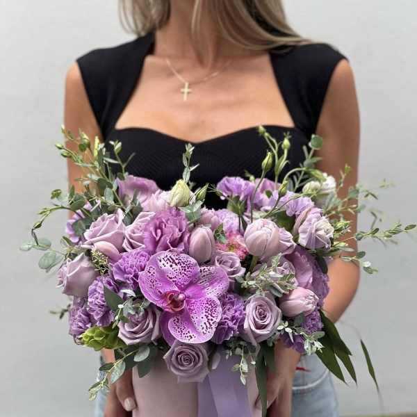 Lavender bouquet with roses, carnations, and an orchid in a pink hat box