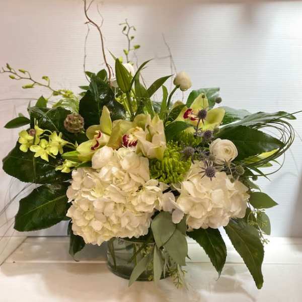 White and green floral arrangement in a glass vase