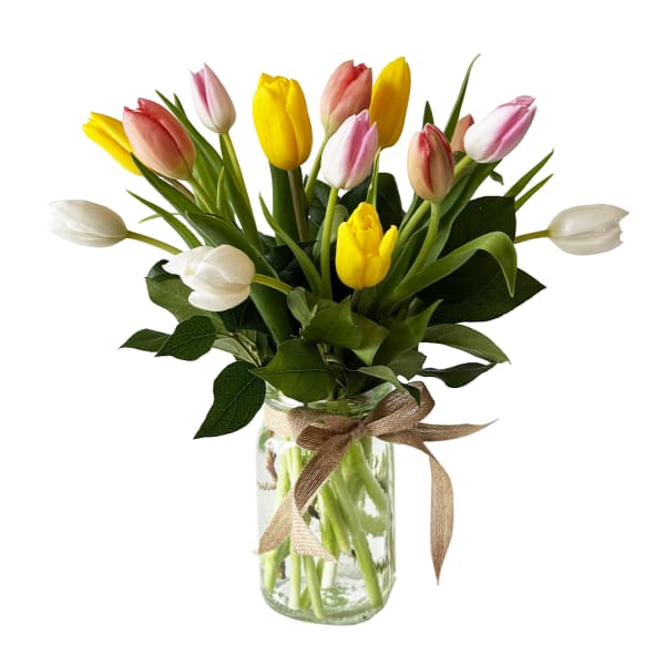 Bouquet of pink, yellow, and white tulips in a glass jar vase