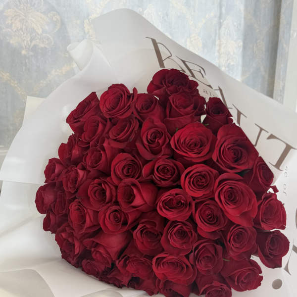 Large bouquet of red roses wrapped in white paper