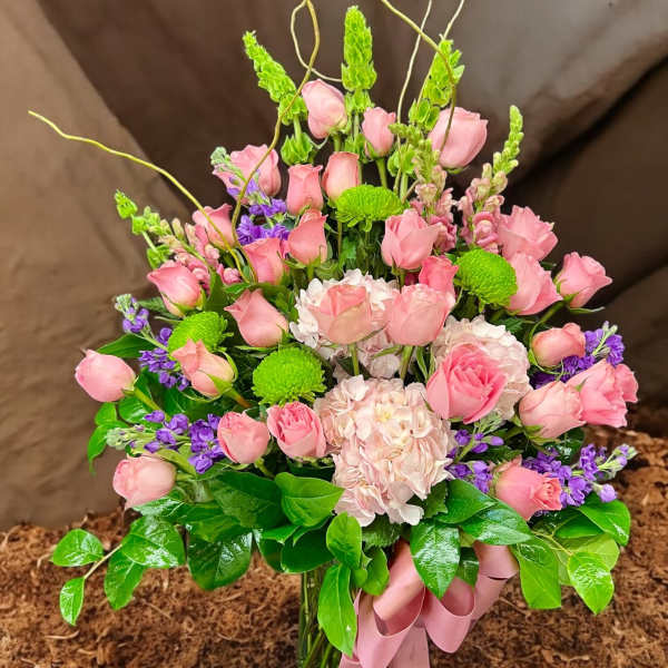 Tall pink rose and hydrangea arrangement with green mums and bells of Ireland in a glass vase
