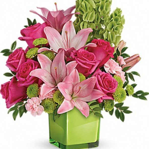 Pink lilies and roses in a green square vase