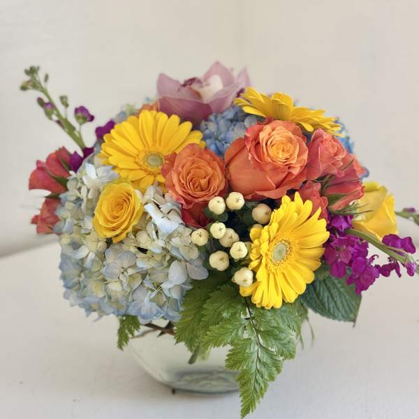 Colorful bouquet with roses, hydrangea, and yellow daisies in a vase