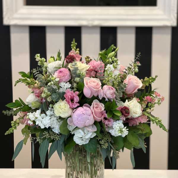 Pink and white floral arrangement in a clear glass vase
