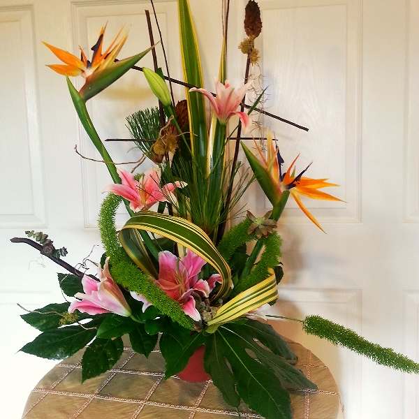 Tall tropical arrangement with pink lilies and orange bird-of-paradise flowers