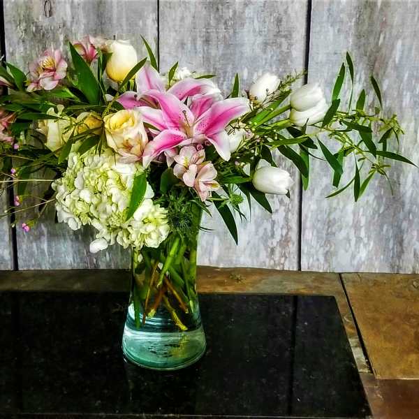Pink lilies and white roses in a glass vase