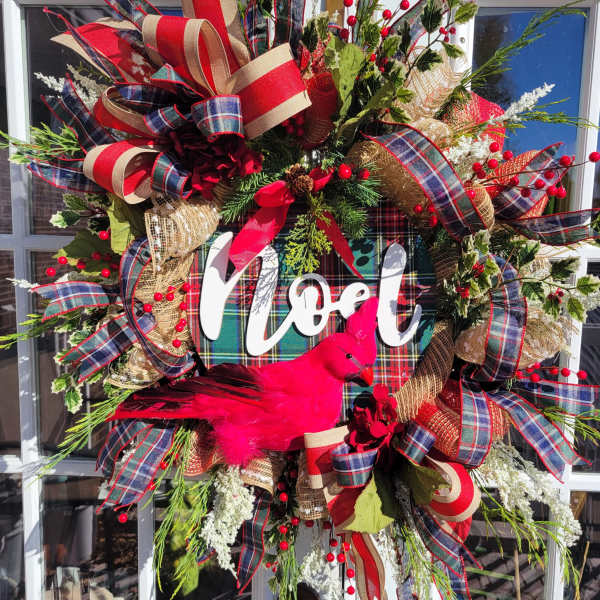 Christmas wreath with plaid ribbons, berries, and a pink bird