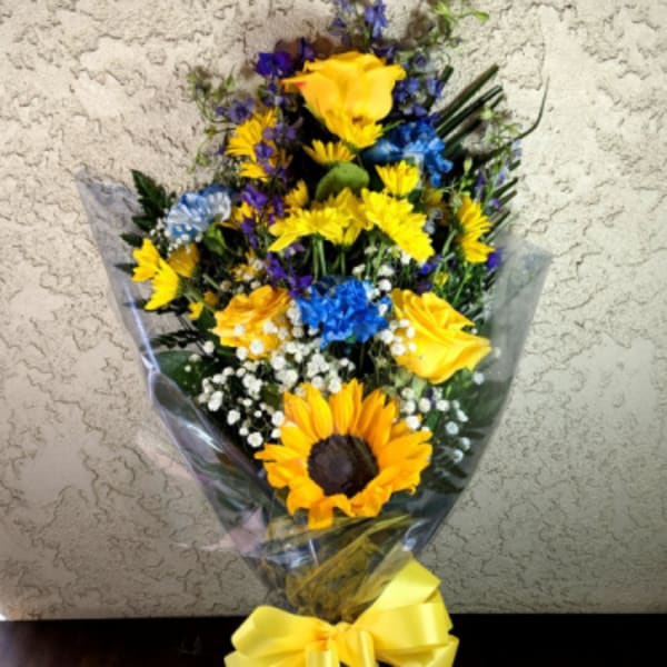 Bouquet of yellow sunflowers and blue flowers wrapped with a yellow ribbon
