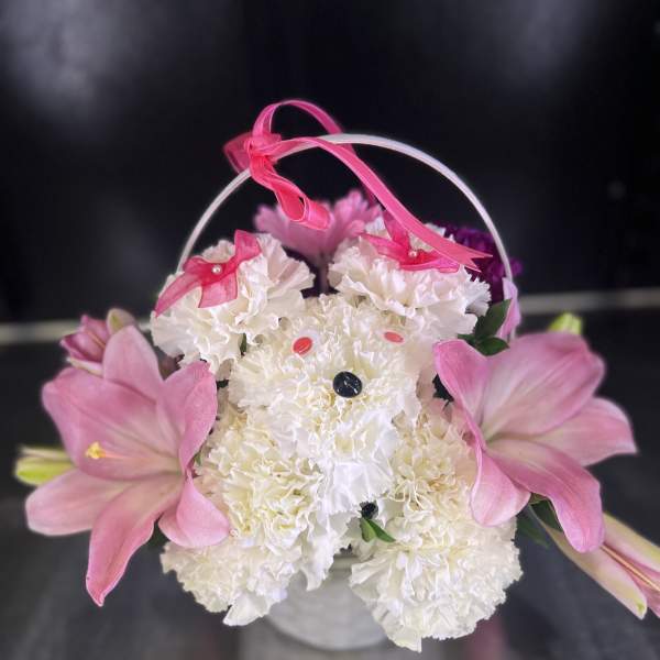 White carnations with pink lilies in a small basket