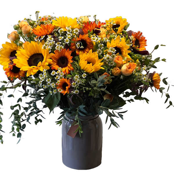 Bouquet of sunflowers and orange blooms in a dark vase