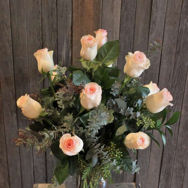 Bouquet of pale peach roses in a clear glass vase