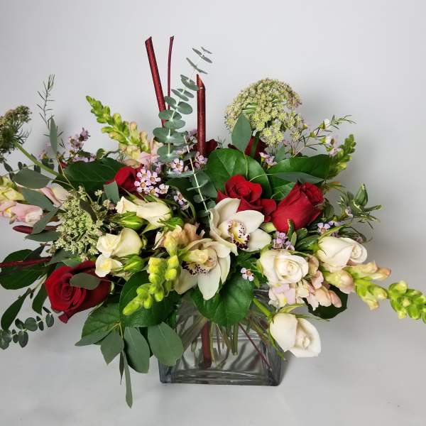 Mixed bouquet of red and white flowers in a clear glass vase