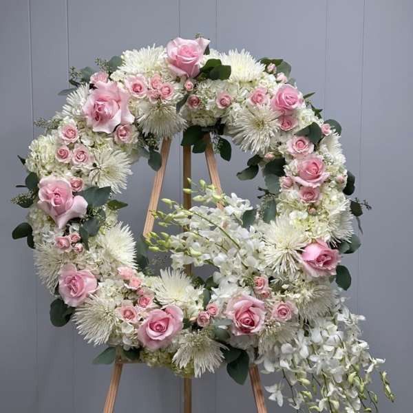 Pink and white floral wreath on a wooden easel