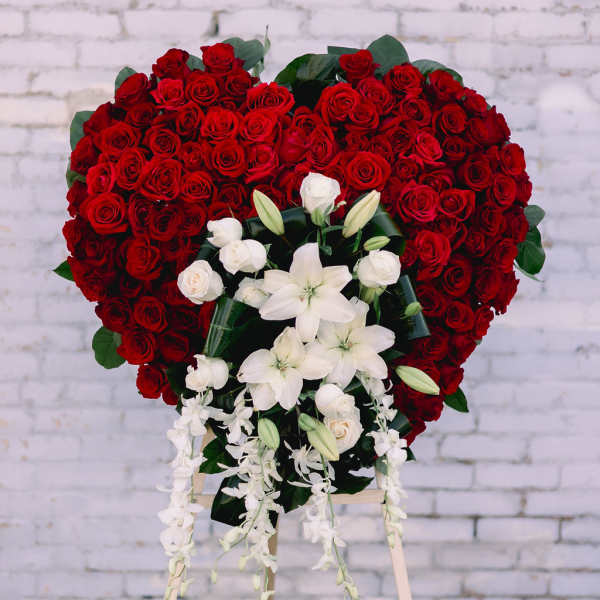 Heart-shaped red rose standing spray with white lilies and orchids