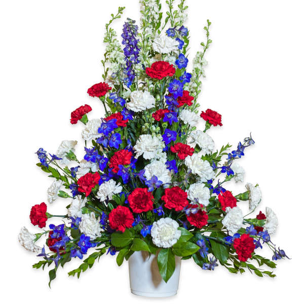 Red, white, and blue floral arrangement in a white vase