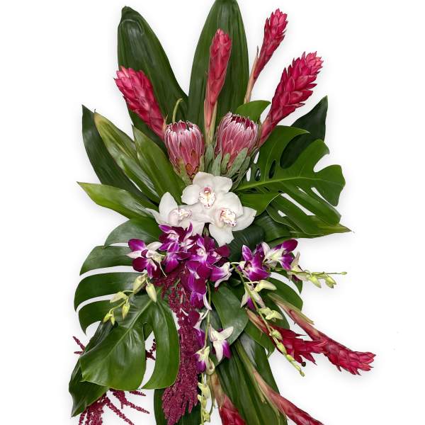 Tropical bouquet with pink ginger, orchids, and large green leaves