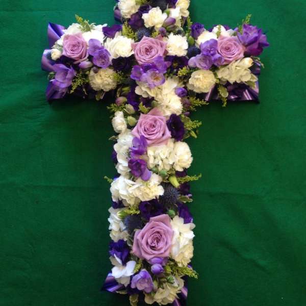 Purple and white floral cross arranged in a cross shape