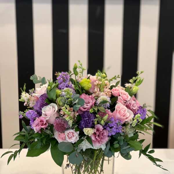 Pink and purple mixed bouquet in a clear glass vase