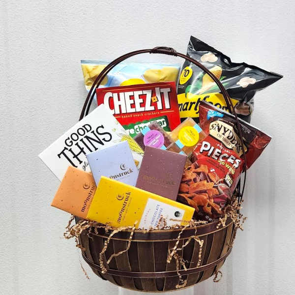 Gift basket with assorted snacks and chocolate bars in a wooden basket