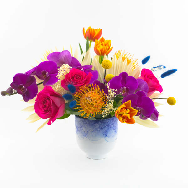 Colorful bouquet of roses and orchids in a blue ceramic vase