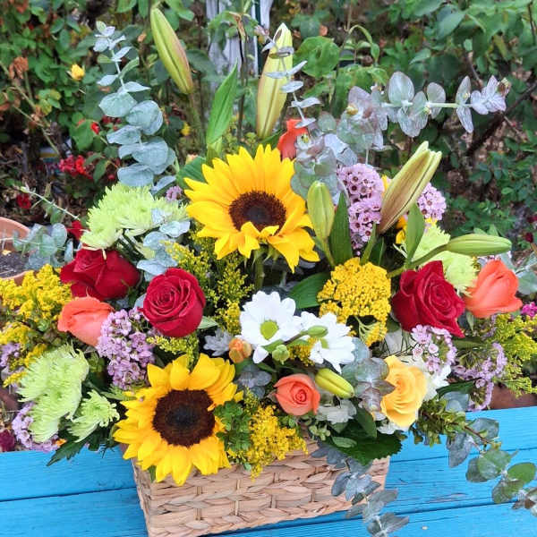 Basket arrangement with sunflowers, roses, lilies, and daisies