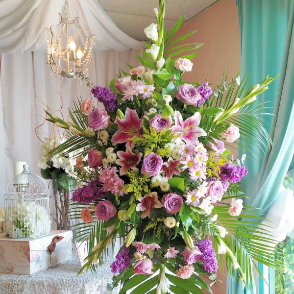 Large pink and purple floral arrangement on a stand