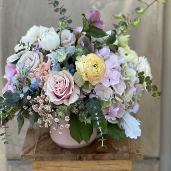 Pastel bouquet in a pink vase with roses, hydrangeas, and ranunculus