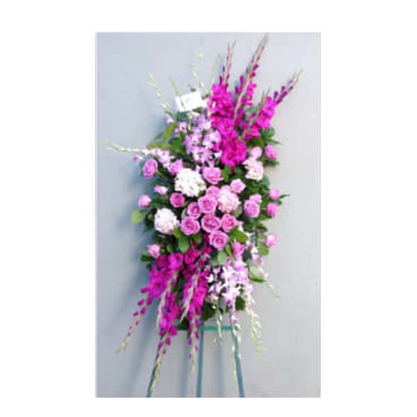 Tall pink and white floral standing spray on a metal easel