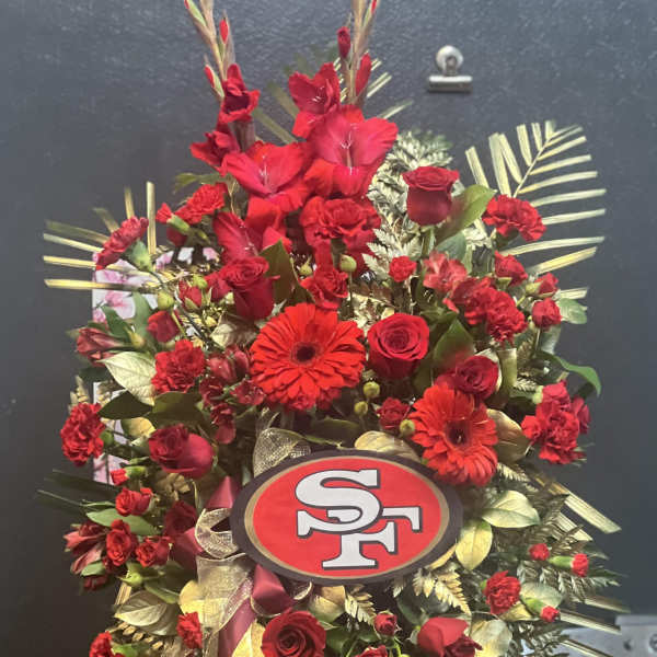 Red floral standing spray with roses and gerbera daisies on an easel