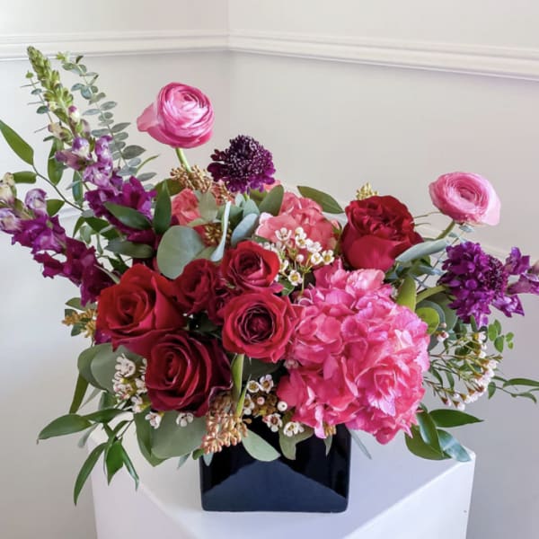Bouquet of pink and red flowers in a black vase