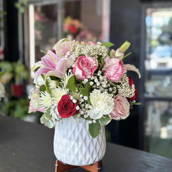 Pink and white mixed flower arrangement in a white vase