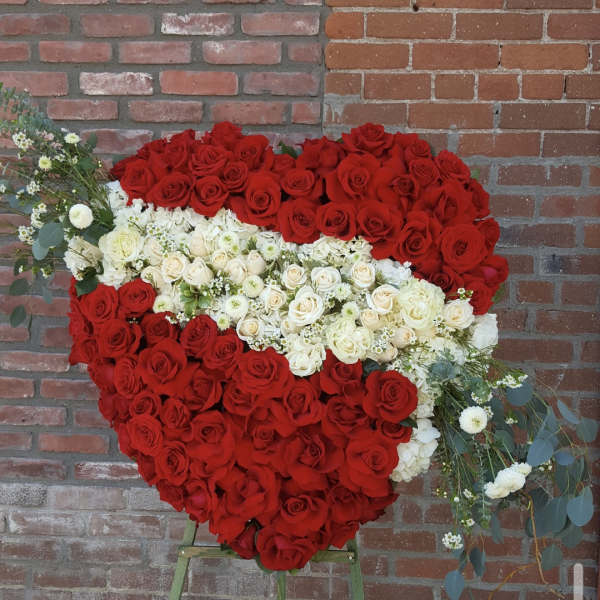 Heart-shaped rose arrangement on an easel with red and white roses