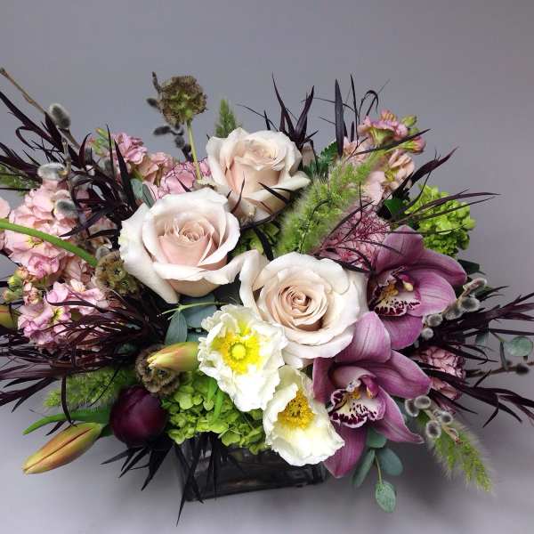 Mixed bouquet with pale roses, purple orchids, and white blooms