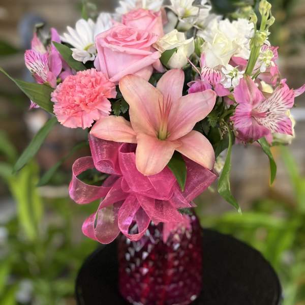 Pink and white mixed bouquet in a magenta vase with a large ribbon