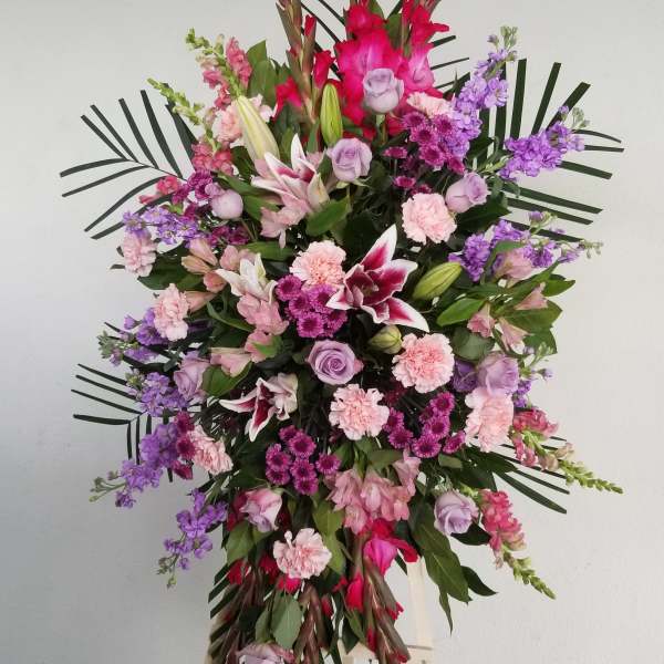 Large standing floral spray with pink, purple, and white blooms on an easel