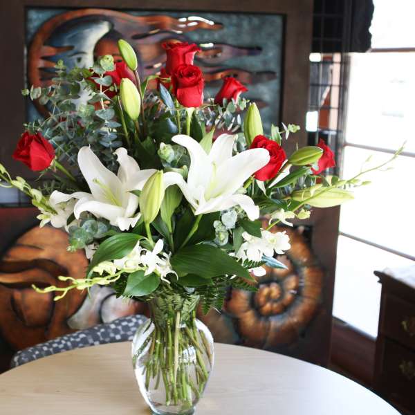 Red roses and white lilies in a clear glass vase