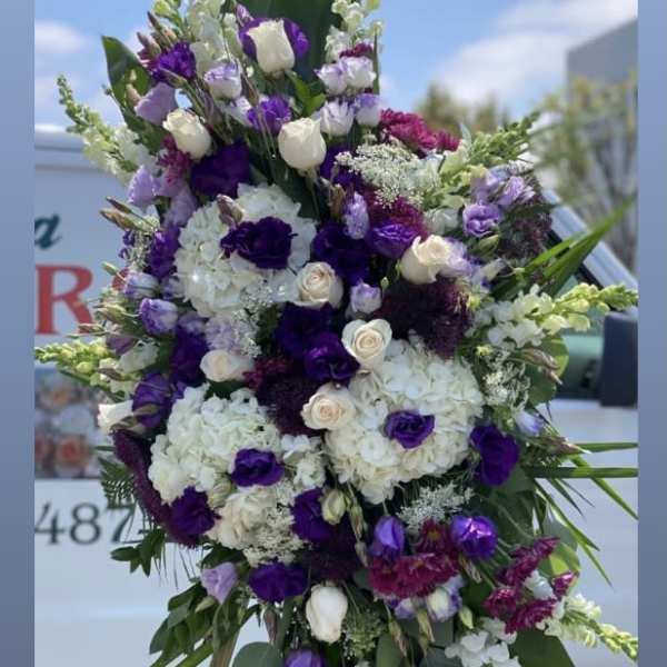 Tall purple and white floral standing spray on an easel