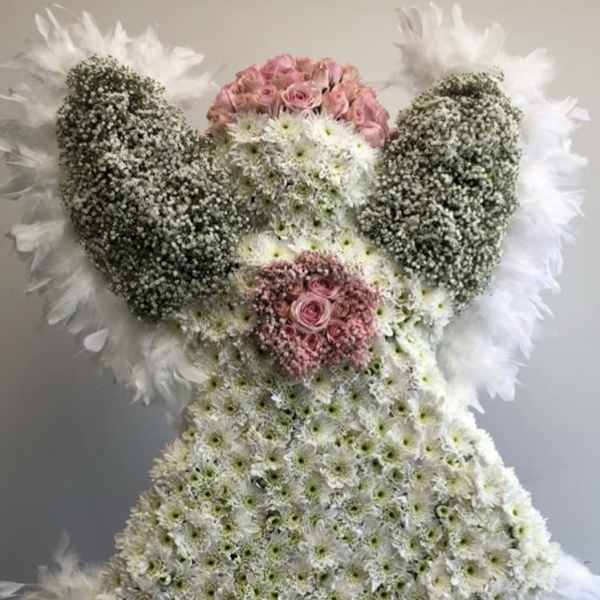 Large floral standing spray shaped like an angel with pink roses and white flowers