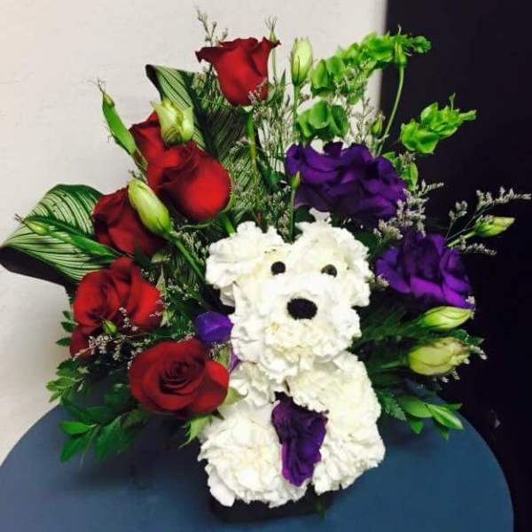 Bouquet with red and purple roses and a white teddy bear made of flowers