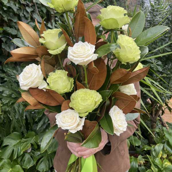 Bouquet of white roses and lime-green carnations with glossy foliage