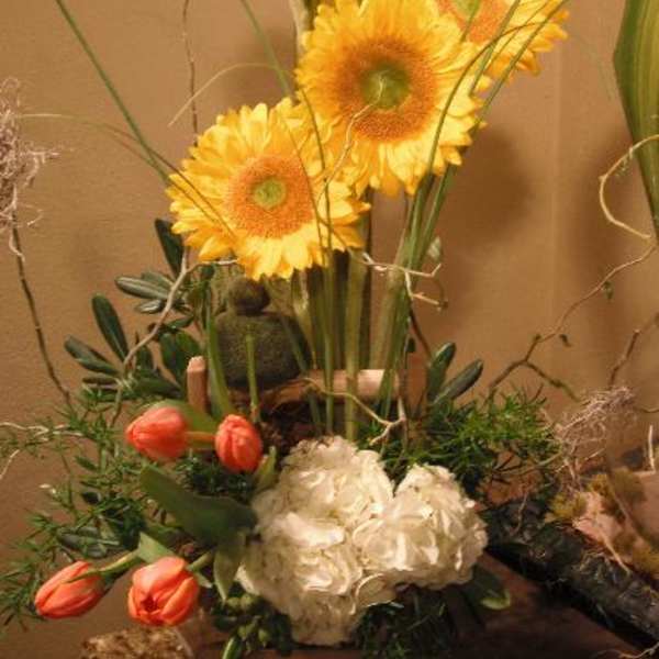 Tall floral arrangement with yellow gerbera daisies and coral tulips